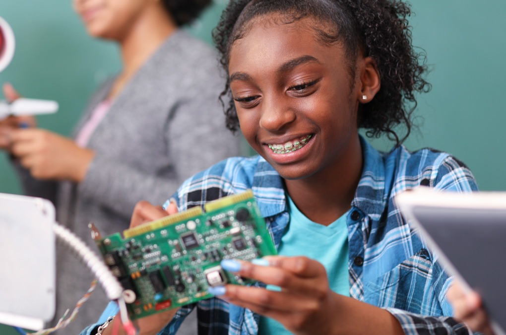 Young woman holding a circuit board